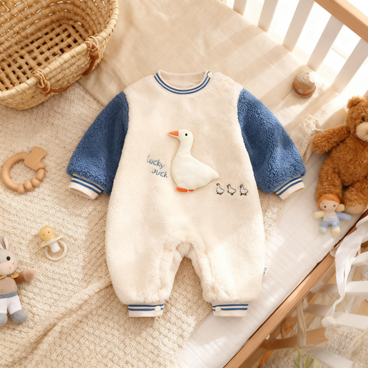 Baby onesie with duck design on a crib with toys around