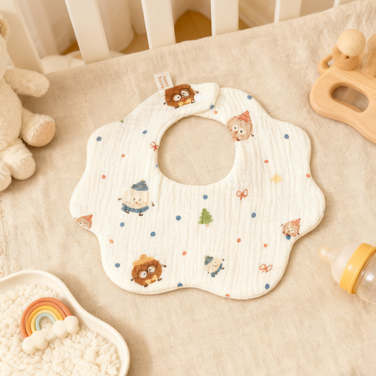 Baby bib with animal patterns on a beige surface with toys around