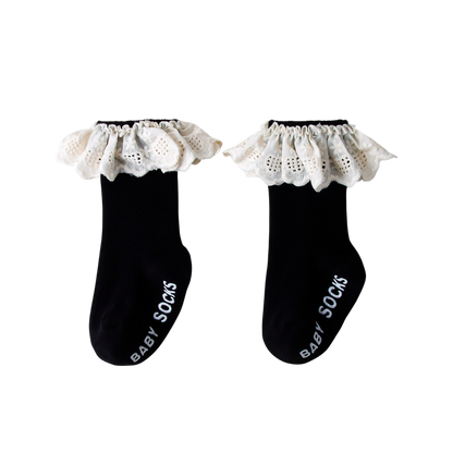 Pair of black baby socks with white lace trim on a white background