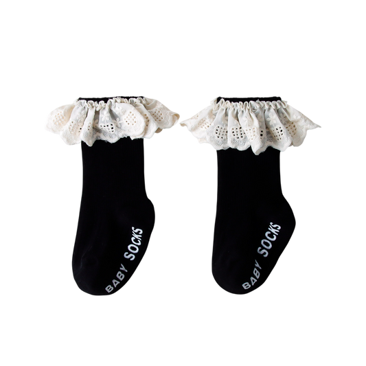 Pair of black baby socks with white lace trim on a white background