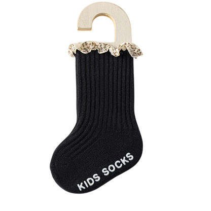 Black kids sock with lace trim on a hanger against a white background