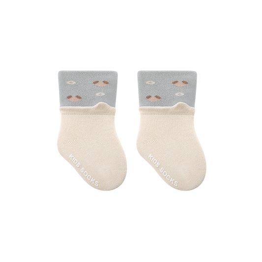 Pair of baby socks with gray tops and beige cuffs on a white background