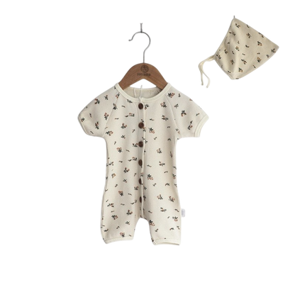 Baby romper with floral pattern and matching hat on a white background