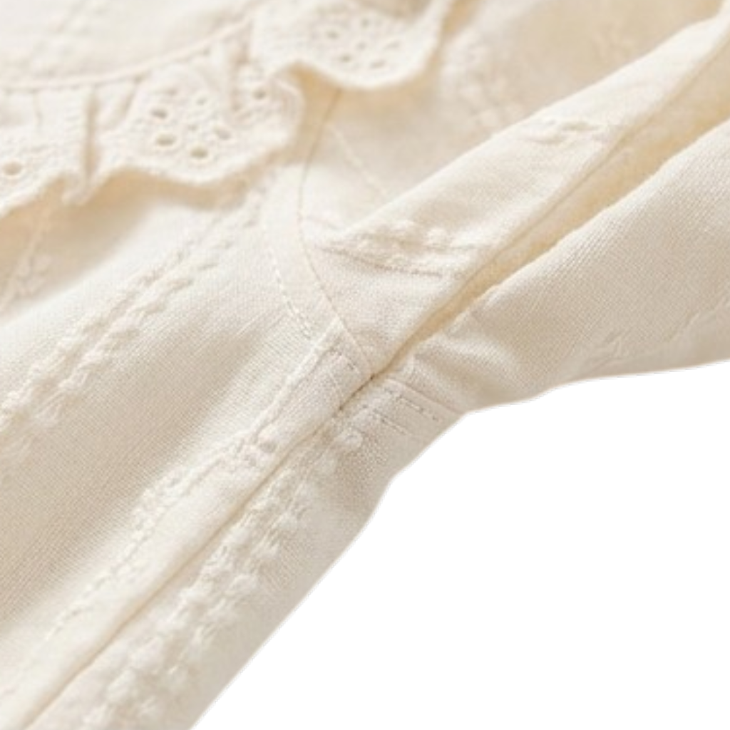 Close-up of the long sleeve and textured fabric on a cream dress