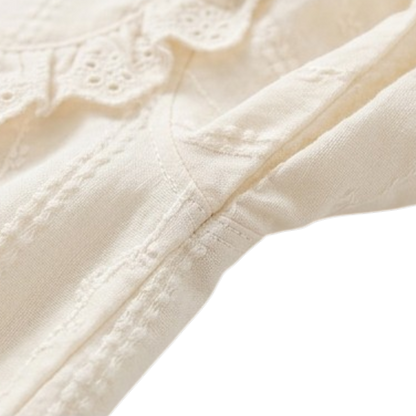 Close-up of the long sleeve and textured fabric on a cream dress