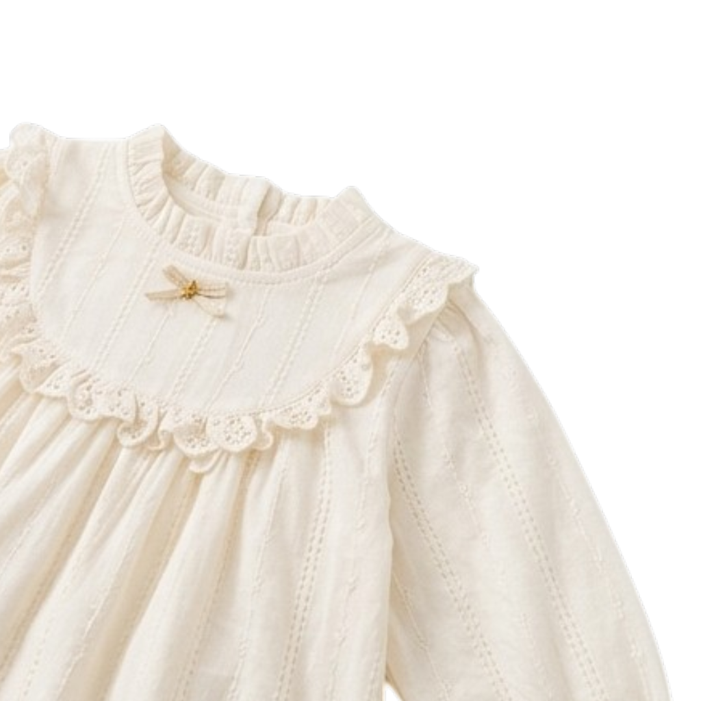 Close-up of a cream dress collar with ruffle trim and a small bow