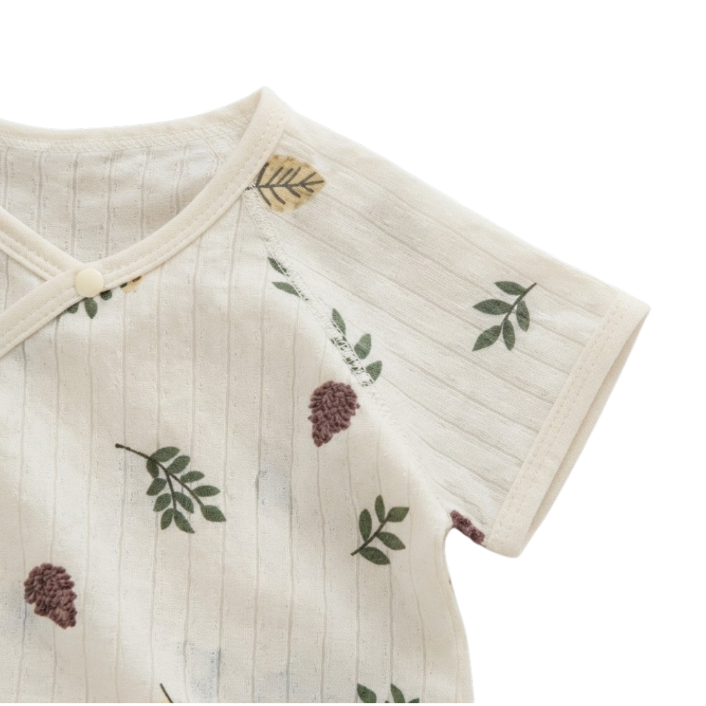 Close-up of the short sleeve and botanical print on the cream baby bodysuit