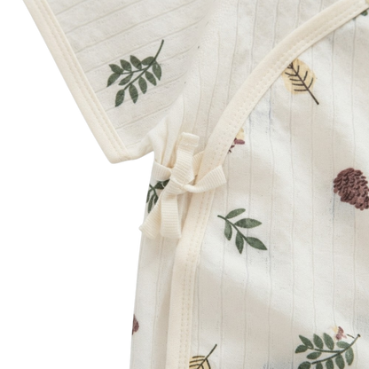 Close-up of the side-tie closure and cream trim on the botanical baby bodysuit