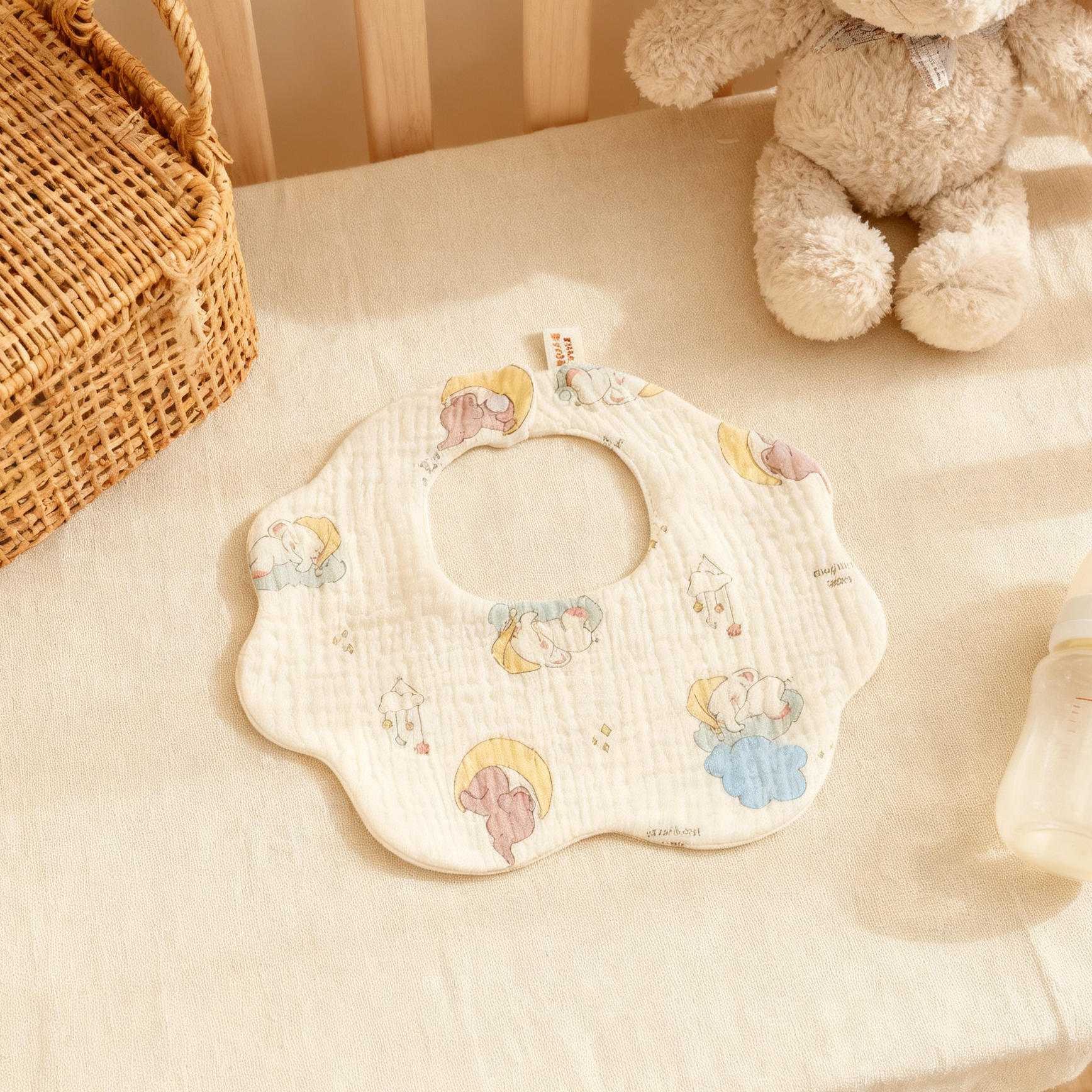Baby bib with cartoon designs on a soft surface with toys in the background