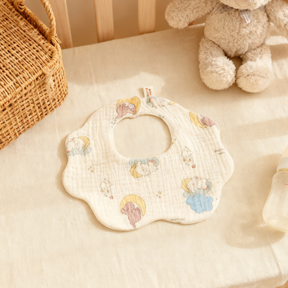 Baby bib with cartoon designs on a soft surface with toys in the background