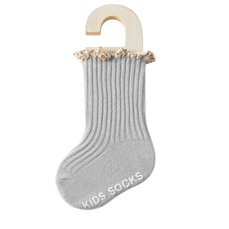Gray kids' socks with beige trim on a wooden hanger against a white background