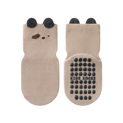 Pair of beige socks with bear face design and black dots on a white background