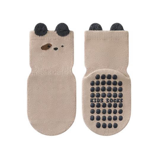 Pair of beige socks with bear face design and black dots on a white background