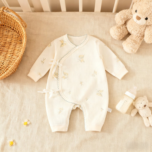 Baby romper with star pattern on a crib with teddy bear and basket