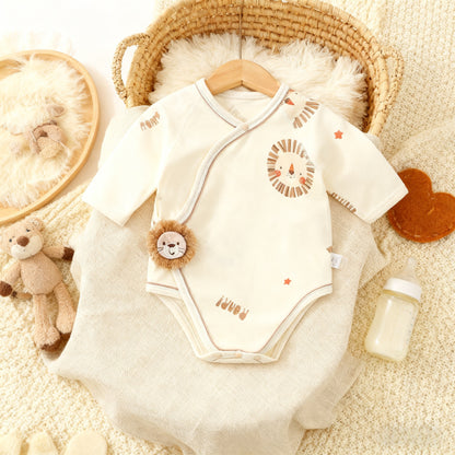 Baby onesie with lion design on a textured surface with toys and a basket.