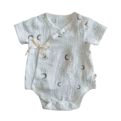 White baby romper with moon pattern on a white background