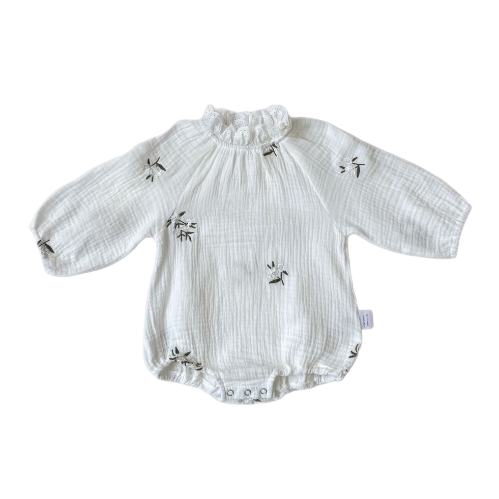 White baby romper with long sleeves and ruffled collar on a white background