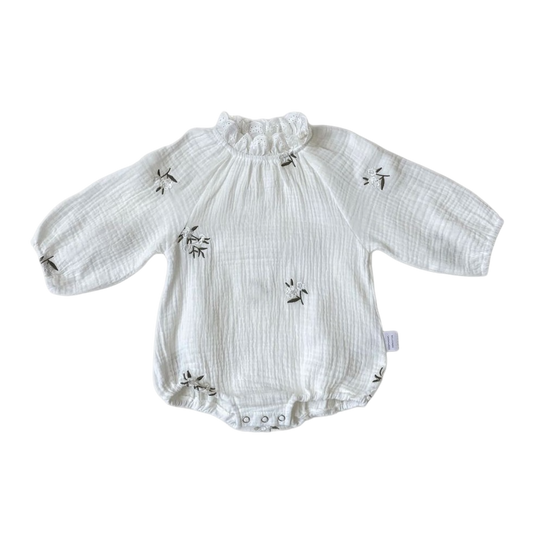 White baby romper with long sleeves and ruffled collar on a white background